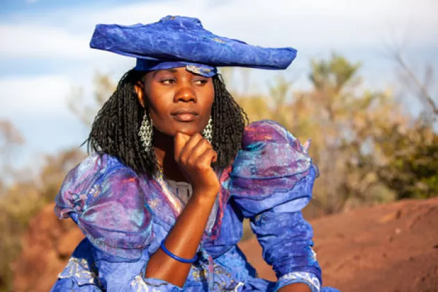  Eine Herero-Frau im viktorianischen Kleid wird im Freien in einem Dorf im Norden von Botswana 