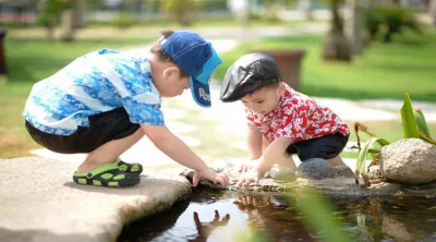 Kinder spielen im Teich